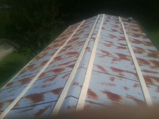 Rusted metal roof panels with new wood purlins before replacement — Storm Damage Roof Repair in Hughes Springs by Roofing Brothers
